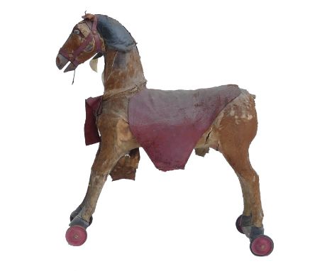 Early 20th century Pull Along horse. Crafted with real horsehide and hair, on wooden bars with tin and enamel wheels. In dist