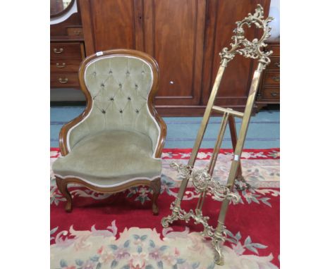 A 20th century mahogany framed button back nursing chair and a brass easel (2) Condition Report: Available upon request