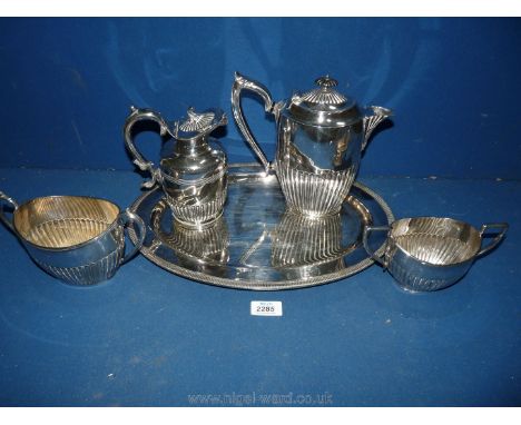 An oval plated serving Tray with coffee pot, water jug and two handled sucrier having a ribbed pattern to the base.