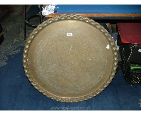 A large brass plaque/Benares table top with Moorish style decoration and pie crust style rim, 28" diameter.