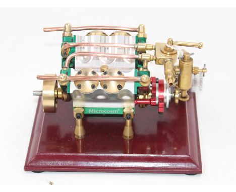 A stationary 4 cylinder "Microcosm" V4 steam engine, comprising of 4 cylinders, fitted with water pump and reserve, fully hou