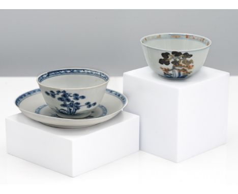 A Nanking Cargo blue and white tea bowl and saucer, 18th century. Each decorated with a pine tree amongst grassy sprigs and t