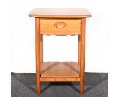 An elm and beech side table, by Ercol, fitted with a single drawer, shaped and recessed handle, with shelf under-tier, grey b