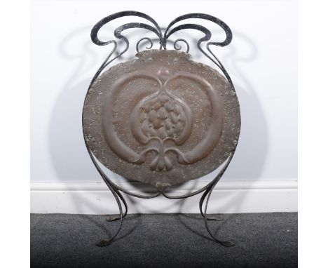 An English Arts and Crafts copper and ironwork firescreen, the main copper panel with large stylised bud against a textured g