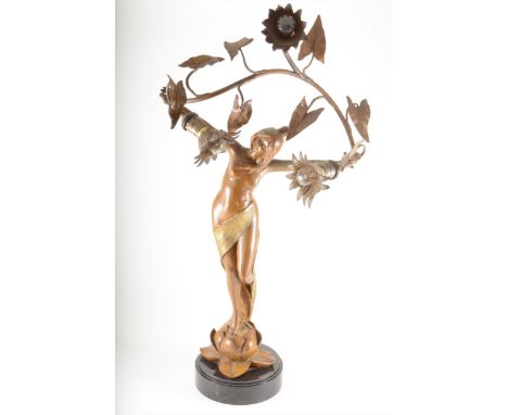 An Art Nouveau patinated spelter figural lamp, signed L Beck, circa 1900, modelled as a maiden holding three branches aloft, 