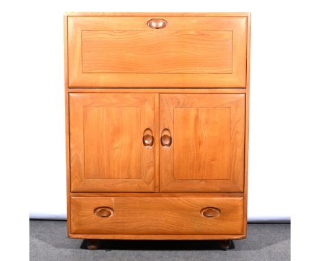 A light elm serving cabinet by Ercol, model 430, fall front with cupboard and drawer, on ball casters, width 73cm, depth 45cm