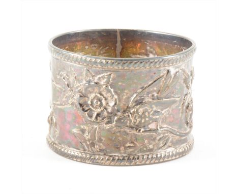 An Arts and Crafts silver napkin ring, by Charles Horner, Birmingham, 1902, embossed with bird amidst blossom.