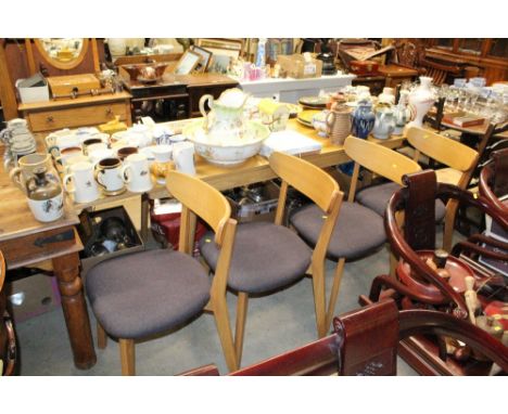 A light oak drawer leaf dining table together with a set of four light oak upholstered dining chairs