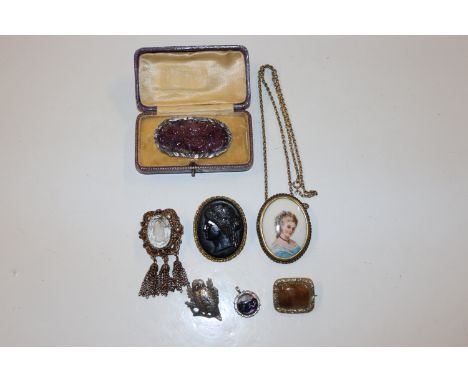 A white metal and carved amethyst coloured stone brooch, a cameo style brooch, a limoges portrait brooch , a silver and Blue 