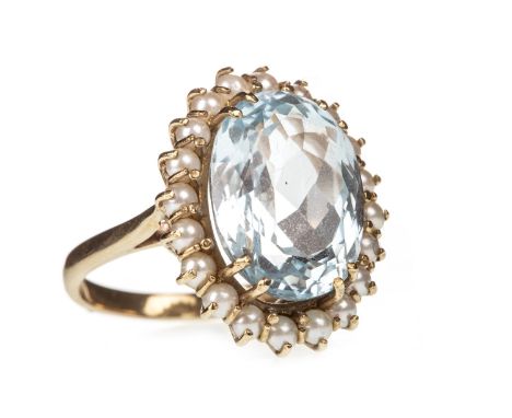 BLUE GEM AND PEARL RING, the faceted oval blue gem 15x12mm, within a halo of split seed pearls, in nine carat gold, size O, 7