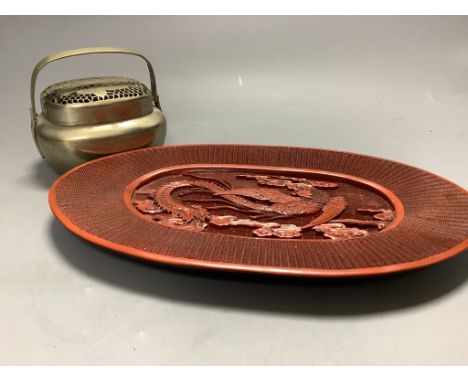   A Chinese lacquer and composition dish and a bronze hand warmer, length 27cm