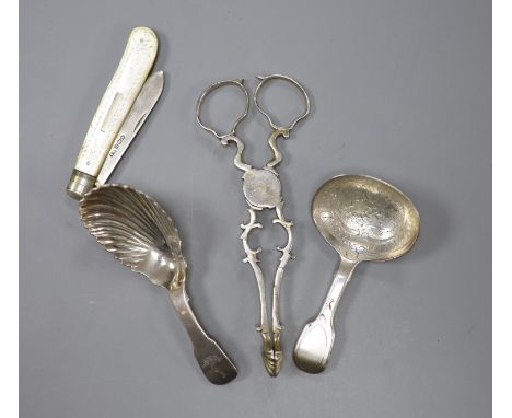   A pair of 18th century silver sugar nips, two later silver caddy spoons and a mother of pearl and silver fruit knife.