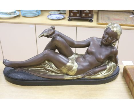   An Art Deco style painted plaster reclining nude holding a dove, length 75cm