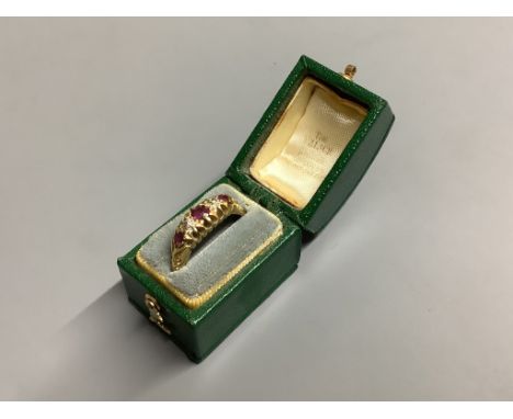   An Edwardian 18ct gold, three stone ruby and two stone diamond set half hoop ring,size M, gross weight 3.9 grams.