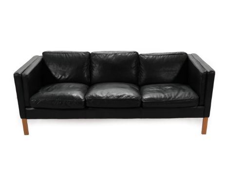 A 1970's Danish Stouby Three-Seater Sofa, upholstered in black leather, with eight cushions, 186cm by 81cm by 70cm