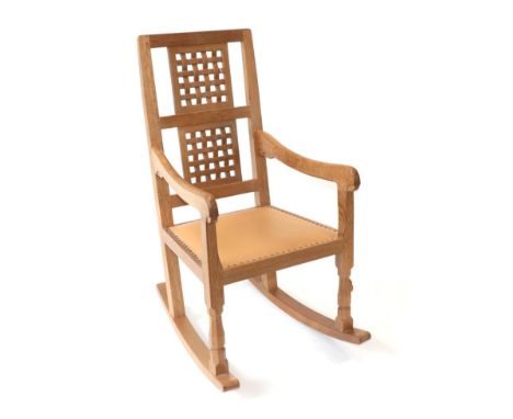 Mouseman: A Robert Thompson of Kilburn English Oak Rocking Chair, with two lattice panel backs, shaped arms and cow hide seat