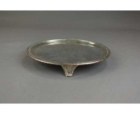 A George III silver salver, IM, London 1804, of circular form with gadrooned rim and raised on three bracket feet, weight 17o