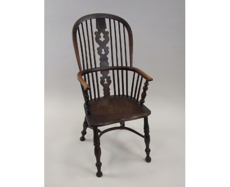 An elm and ash Windsor chair with pierced splat and stick back and crinoline stretcher raised on ring turner baluster legs