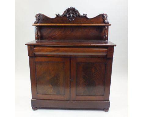 A Victorian mahogany chiffonier, the low panel back with foliate scroll border above a narrow shelf on S-scroll brackets over