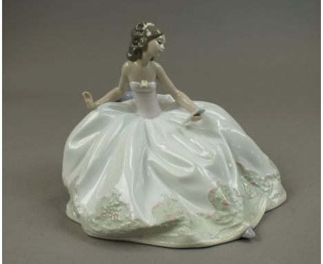 A Lladro figure 'At the Ball/Sentada en la Fiesta', no. 5859, modelled as a lady with large flowing ballgown, seated at a ben