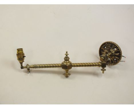 A Victorian brass adjustable wall light fitting converted to electricity, in Gothic style, the swing arm, 35cm long, and a st