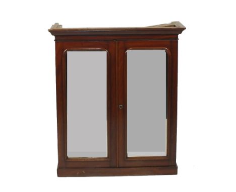 A Victorian mahogany cabinet top, the ogive cornice above two indented arched mirrored doors enclosing an adjustable shelf an