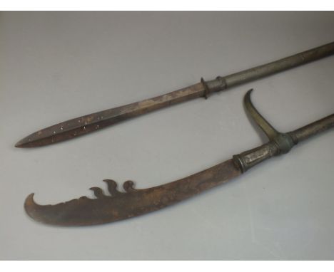 Two South East Asian pole arms19th/20th CenturyThe first of naginata type with flame shaped blade above a parrying hook, the 