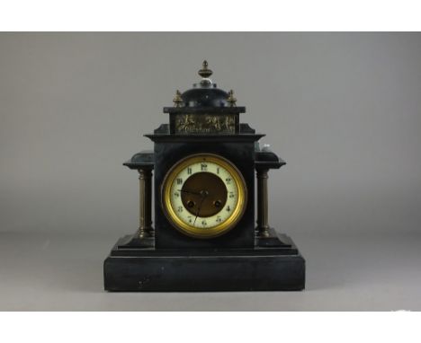 A Victorian black marble mantel clock, with domed architectural case inset with a brass panel of putti in a chariot driven by