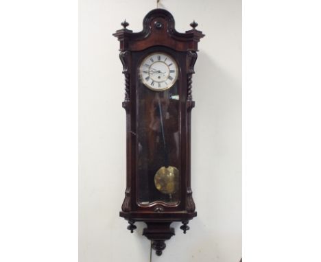 A rosewood cased Vienna style wall clock, late 19th century, the shaped arched top between two finials over an arched glazed 