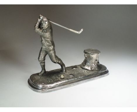 A novelty silver plated inkwell, designed as a golfer mid swing mounted to elongated naturalistic textured base set with tree