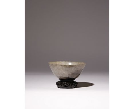 A CHINESE MOTTLED GREY AND BLACK JADE BOWL QING DYNASTY With curved sides gently thinning towards the rim, the recessed base 