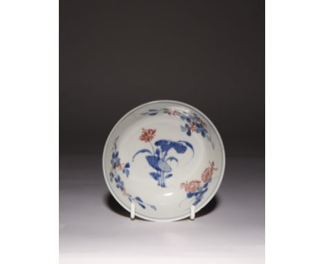 A CHINESE UNDERGLAZED BLUE AND COPPER-RED BOWL KANGXI 1662-1722 The interior decorated with lotus sprays to the centre, encir