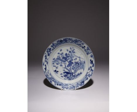 A CHINESE BLUE AND WHITE 'MASTER OF THE ROCKS' DISH KANGXI 1662-1722 The shallow rounded sides rising from the tapering foot 