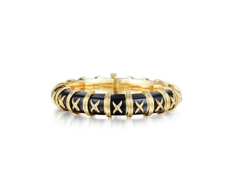 Crafted out of 18K yellow gold with black enamel; circumference measures 6-1/2 inches, width 1.3 cm; weight 90.6 g.; retails 