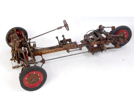 A Meccano home built model of a three-wheel motor vehicle comprising of various 1950s and earlier components with red hubs an