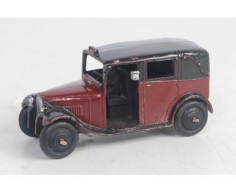 A Dinky Toys No. 36G taxi comprising maroon and black body pre-war type body with open rear window but fitted with post-war r