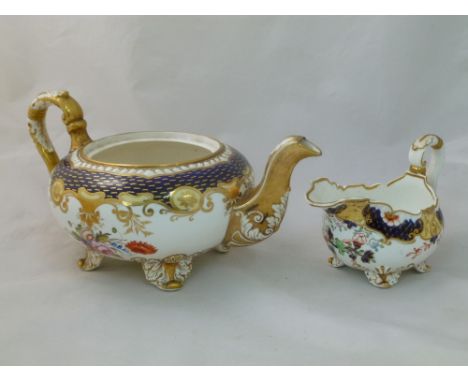 An H & R Daniel porcelain cream jug and teapot, the cream jug Shrewsbury shape with acanthus scroll handle and feet, decorate