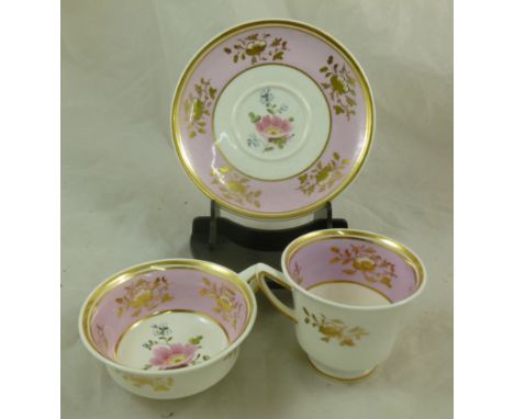 An H & R Daniel porcelain trio, Etruscan shape, decorated with a pink band containing gilt floral sprays and central enamelle