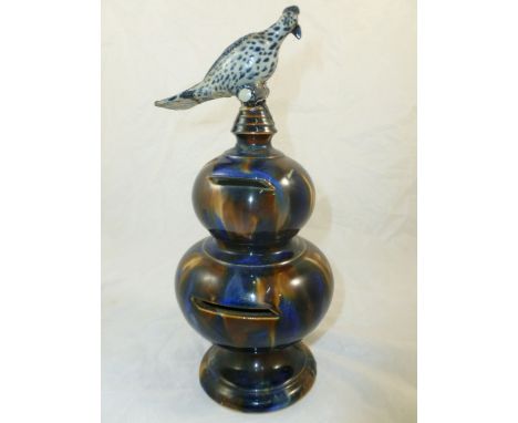A double gourd stoneware money box with mottled brown and blue glaze and bird finial, 23.5cm high - Part of a private owner c