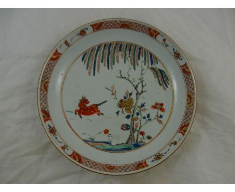 A Kangxi porcelain famillè vert dish decorated with a horse and a willow tree, 23cm diameter