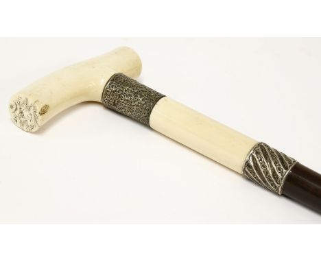 A heavy ivory and ebony walking stick,19th century, the ivory handle engraved with Gothic initials and an heraldic device ins