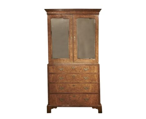 A George I figured walnut cabinet,the top with a moulded cornice over mirrored doors enclosing an arrangement of fifteen feat