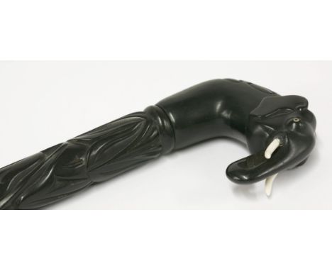 An Indian ebony walking stick,early 20th century, carved with an elephant's head handle over a carved shaft,87cm high