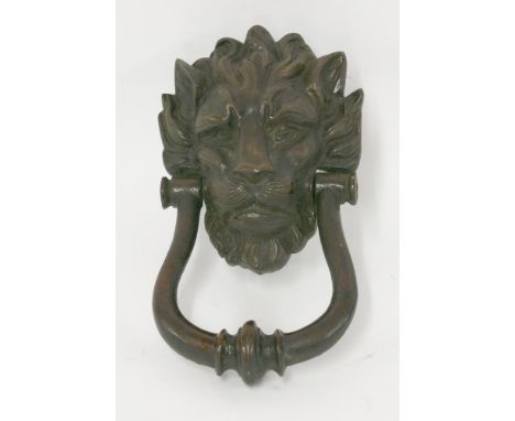 A heavy brass door knocker,cast in the form of a quizzical lion's mask