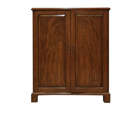 A George III mahogany cabinet,the panelled doors enclosing an interior fitted with sliding shelves and four drawers below, on