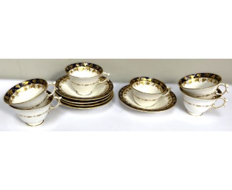 An early 20th c. Royal Worcester tea set of six cups and saucers, cups 6 cm, with gilt scrolling vine decoration, one cup lac