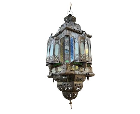 A Morrocan hanging lantern or lamp. Of Moorish influence, with pierced metalwork and clear and coloured glass panels, height 