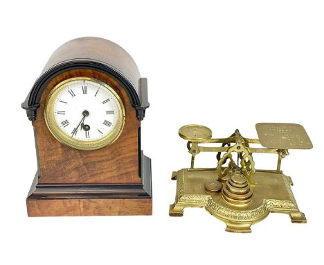A walnut cased continental mantel timepiece.. Circa 1890, with an arched top and ebonised detail, white enamel dial, retailer
