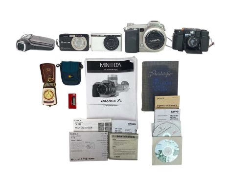 A Minolta Dimage 7i digital camera. Other cameras, including Panasonic Lumix DMC-XS1, Minox 35ML, Casio Exilim, Sanyo Xacti d
