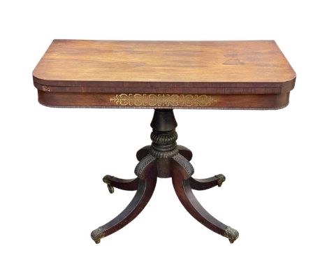 A Regency rosewood and brass inlaid fold-top card table. Raised on a carved pillar and four hipped sabre feet, with cast bras